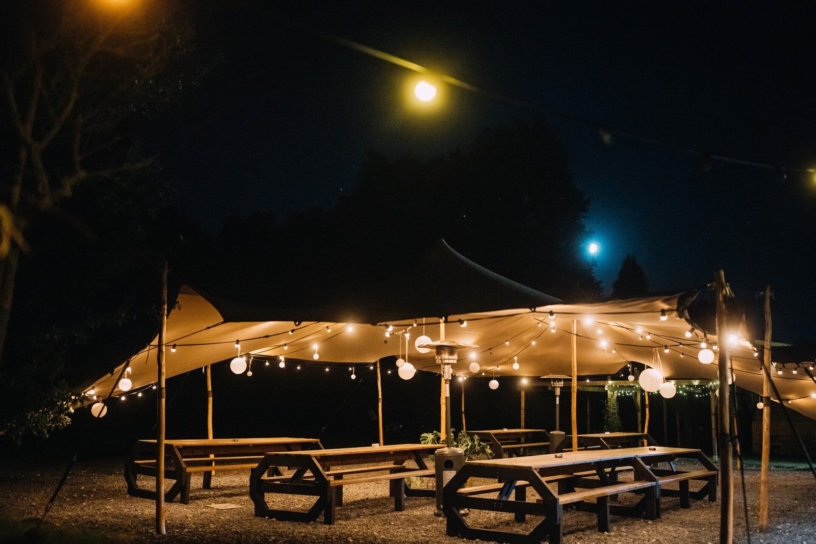 Overdekte tent met sfeerlicht naast de schuur